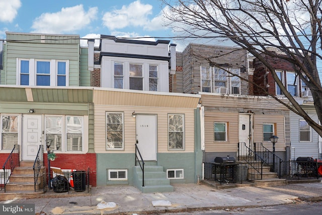 townhome / multi-family property featuring entry steps and cooling unit