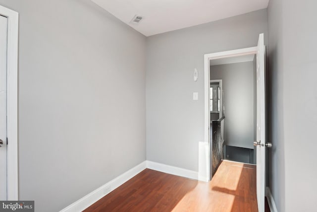 interior space with dark wood-style flooring, visible vents, and baseboards