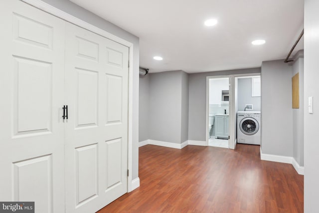 washroom with washer / dryer, baseboards, laundry area, and wood finished floors