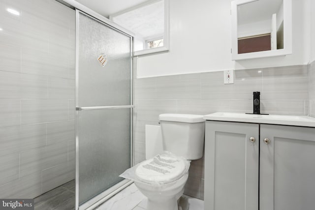 bathroom with toilet, a shower stall, and tile walls