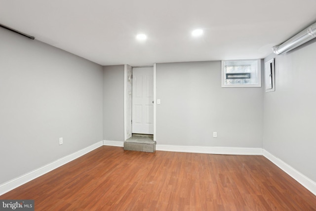 basement featuring recessed lighting, baseboards, and wood finished floors