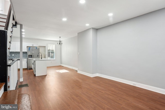 unfurnished living room featuring dark wood-style floors, recessed lighting, visible vents, a chandelier, and baseboards