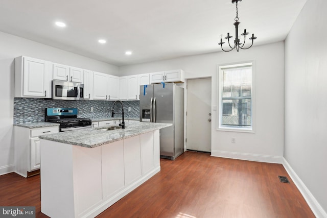 kitchen with white cabinetry, appliances with stainless steel finishes, decorative backsplash, and a sink