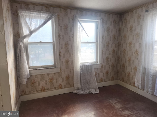 spare room featuring baseboards and wallpapered walls