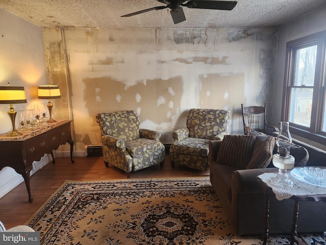 sitting room with a textured ceiling, a ceiling fan, and wood finished floors