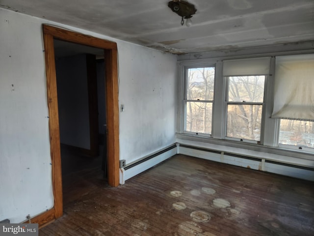 unfurnished room with a baseboard radiator and wood-type flooring