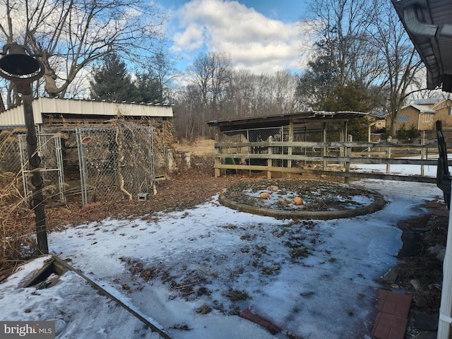 yard layered in snow featuring an outbuilding