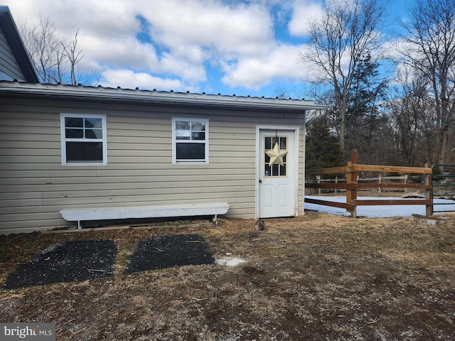 exterior space featuring metal roof and fence