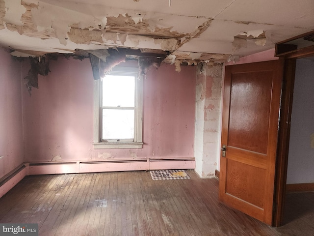 spare room with a baseboard heating unit and hardwood / wood-style flooring