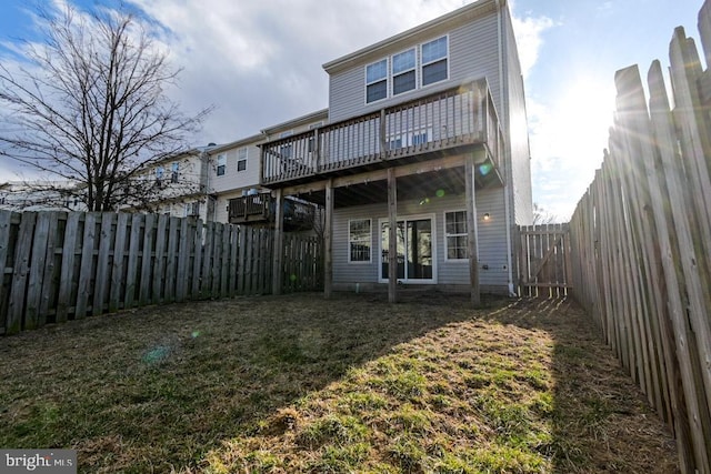 back of property featuring a fenced backyard and a lawn