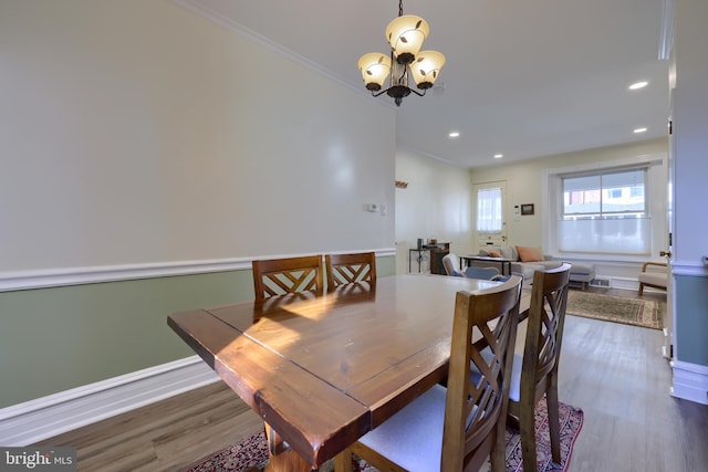 dining space with recessed lighting, an inviting chandelier, ornamental molding, and dark wood-style flooring