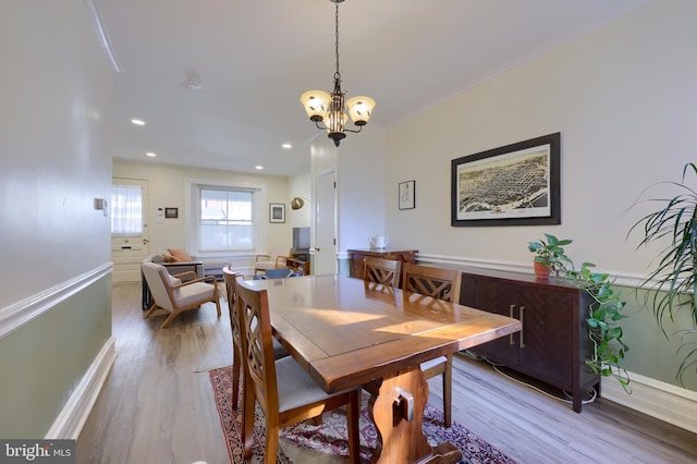 dining room with crown molding, baseboards, recessed lighting, an inviting chandelier, and wood finished floors