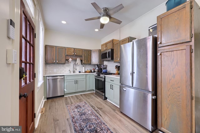 kitchen featuring decorative backsplash, appliances with stainless steel finishes, light countertops, and a sink