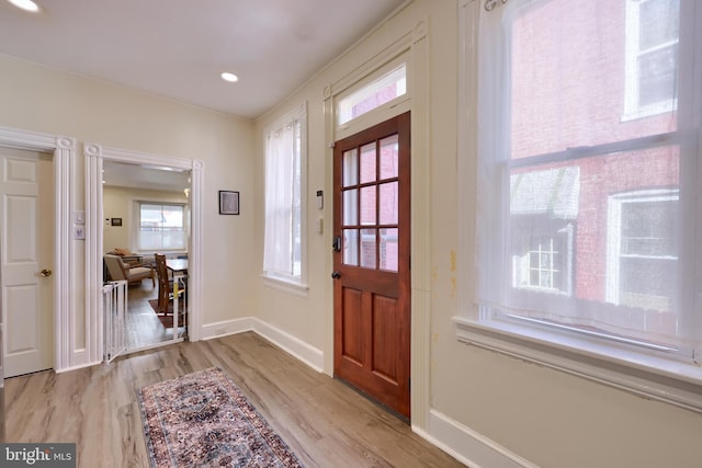 entryway with light wood finished floors, recessed lighting, and baseboards