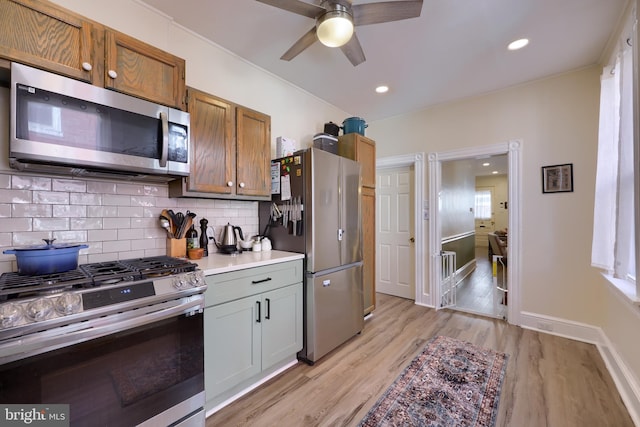 kitchen featuring decorative backsplash, appliances with stainless steel finishes, light wood-style flooring, and light countertops