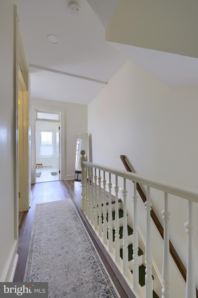 hallway featuring an upstairs landing and wood finished floors