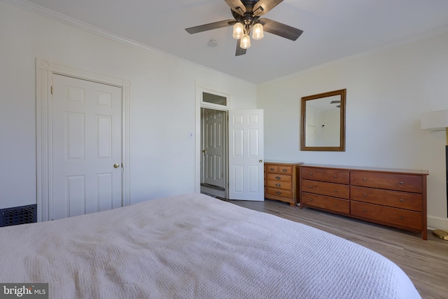 unfurnished bedroom with ceiling fan, wood finished floors, and ornamental molding