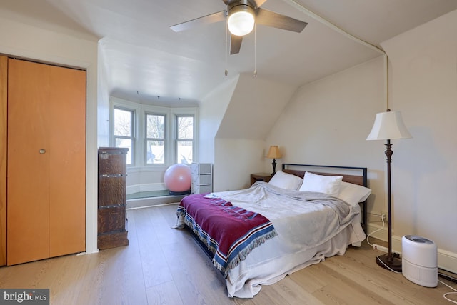 bedroom with baseboards, wood finished floors, a ceiling fan, and vaulted ceiling