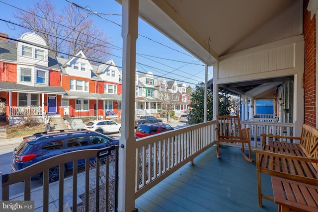 wooden deck featuring a residential view and a porch