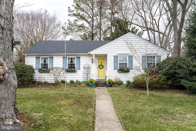 ranch-style house with entry steps, a shingled roof, and a front yard