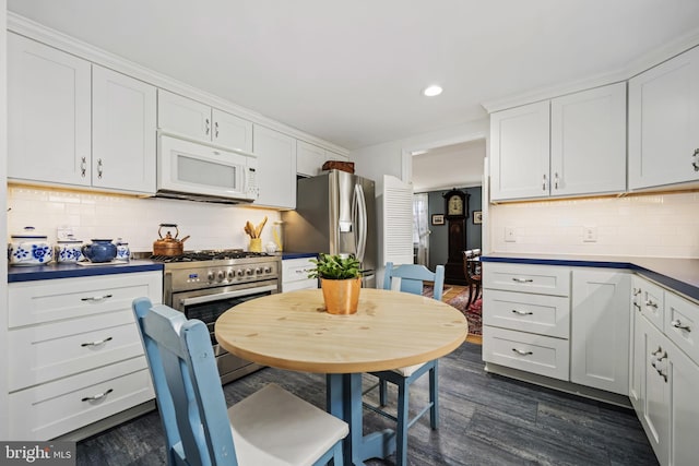 kitchen featuring white cabinets, decorative backsplash, dark wood-type flooring, stainless steel appliances, and recessed lighting