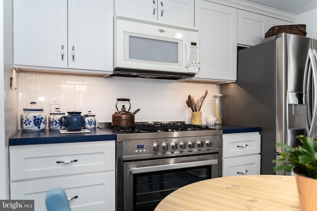 kitchen with stainless steel appliances, backsplash, and white cabinetry