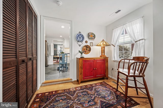 interior space with light wood finished floors, baseboards, and visible vents