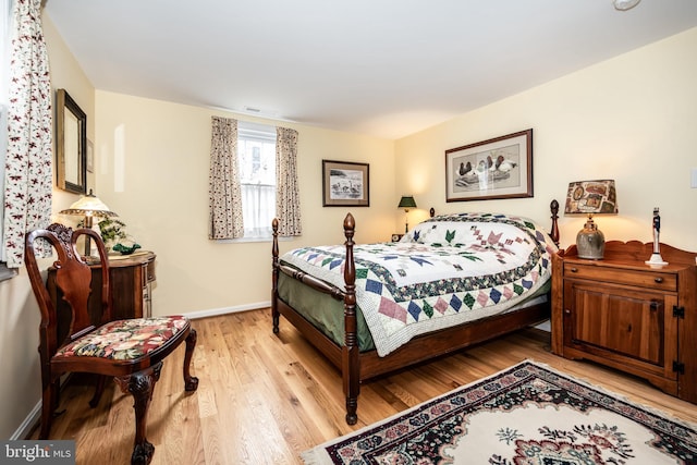 bedroom with visible vents, light wood-style flooring, and baseboards