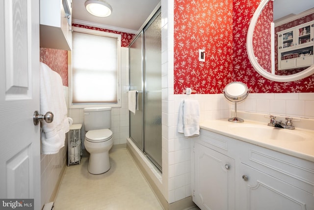 bathroom featuring toilet, wallpapered walls, tile walls, and wainscoting