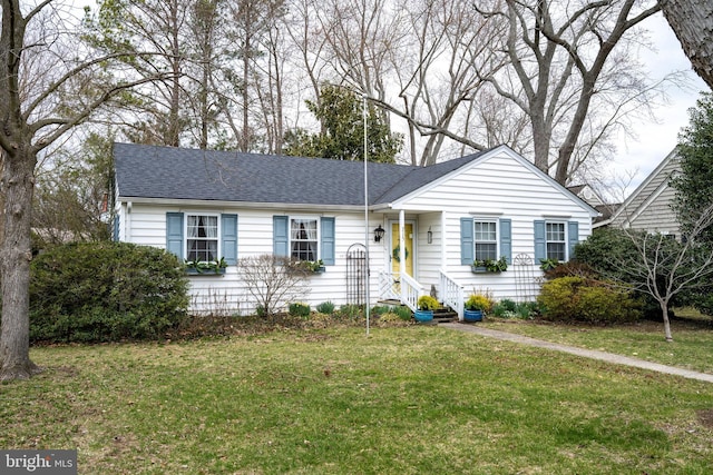 ranch-style home featuring a shingled roof, a front yard, and entry steps