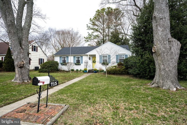 ranch-style home with a shingled roof and a front lawn