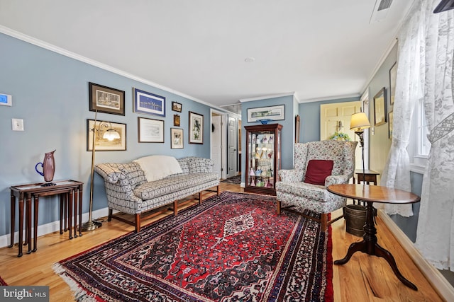 living room featuring crown molding, baseboards, and wood finished floors