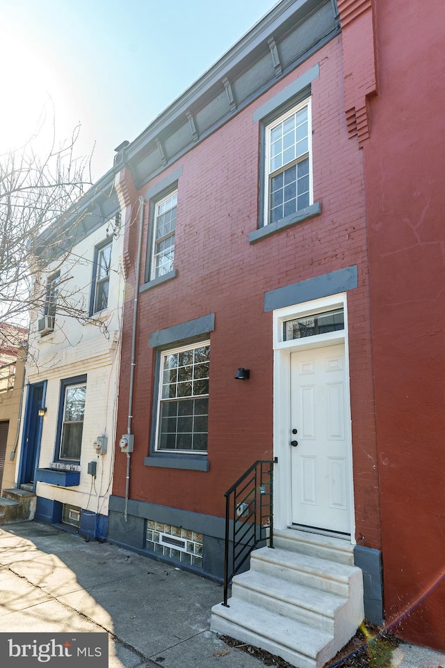 view of front facade with entry steps and brick siding