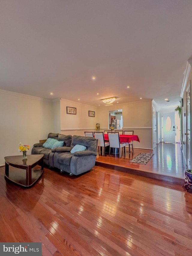 living area with recessed lighting, hardwood / wood-style flooring, and crown molding