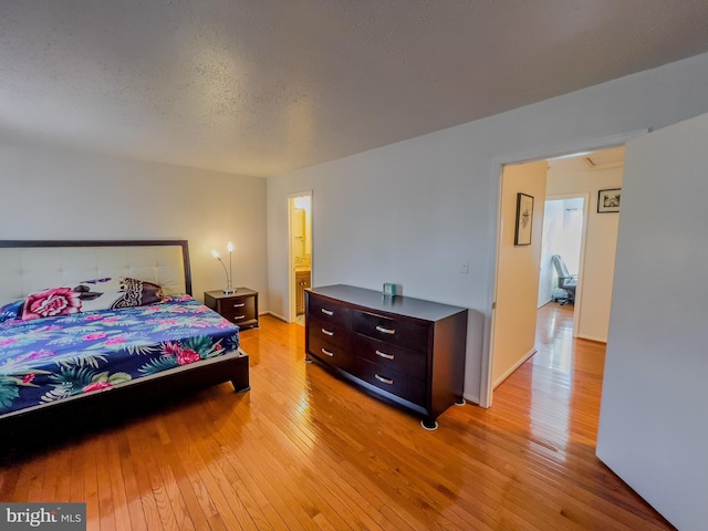 bedroom featuring light wood-style flooring and a textured ceiling