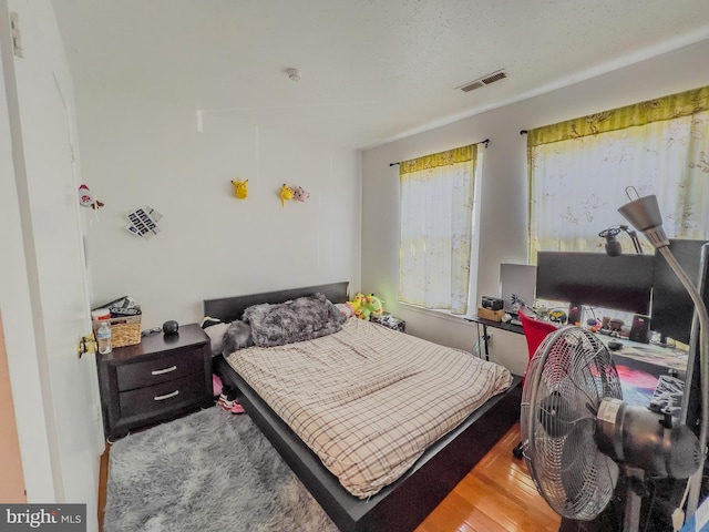 bedroom featuring visible vents and wood finished floors