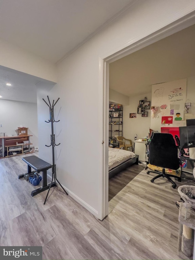 workout room with baseboards and wood finished floors