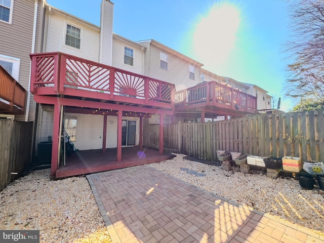 back of property featuring a patio, central AC unit, a fenced backyard, a wooden deck, and a chimney