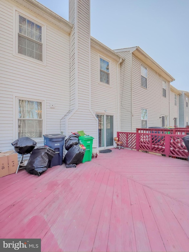 rear view of property featuring a deck and a chimney