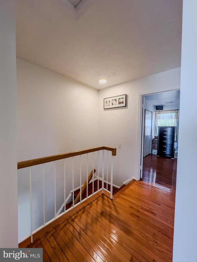 corridor with wood-type flooring and baseboards