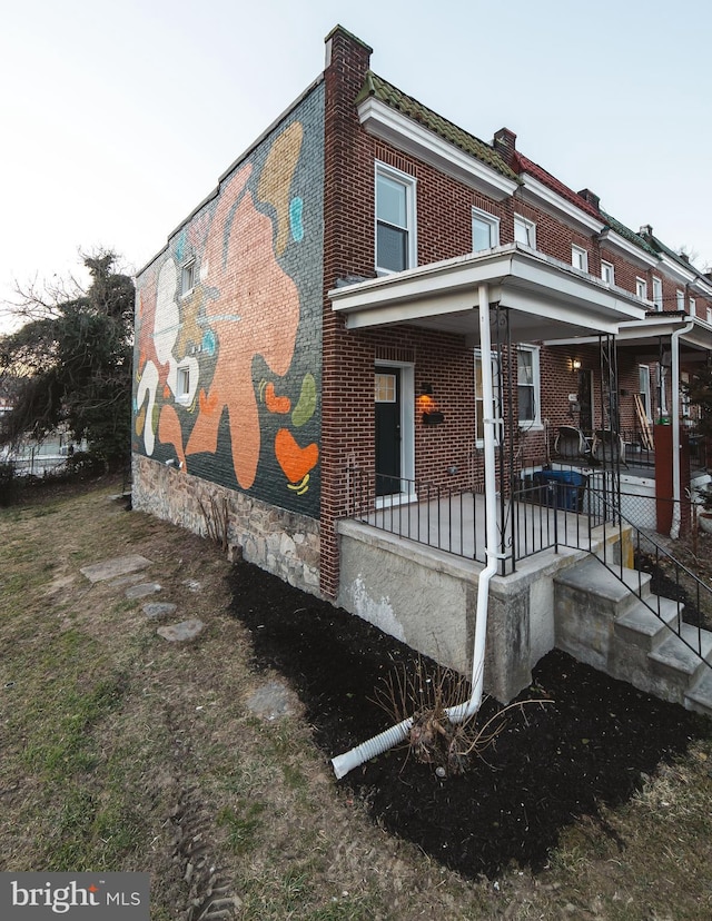 exterior space featuring a porch and brick siding