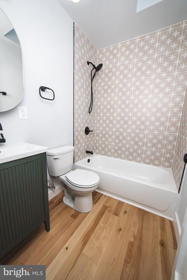 full bath featuring shower / washtub combination, vanity, toilet, and wood finished floors