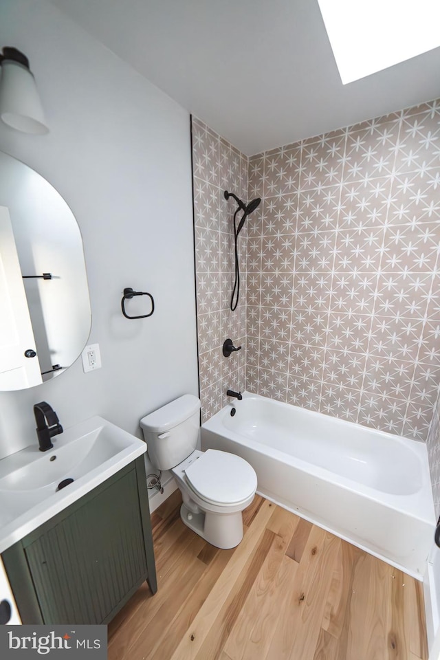 full bathroom featuring toilet, washtub / shower combination, wood finished floors, and vanity