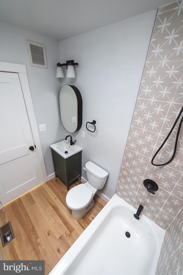 full bathroom with toilet, a shower, wood finished floors, and visible vents