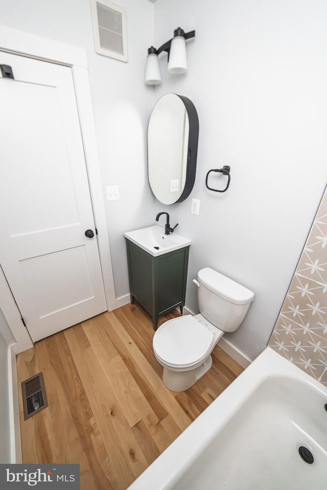 full bath featuring visible vents, vanity, toilet, and wood finished floors