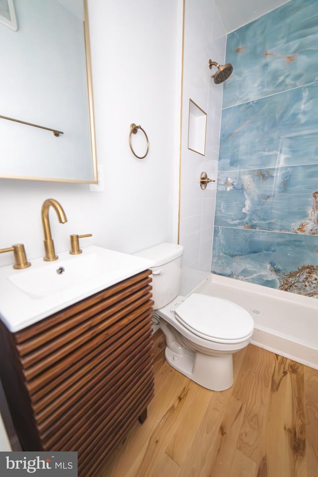 full bathroom with visible vents, toilet, a stall shower, vanity, and wood finished floors