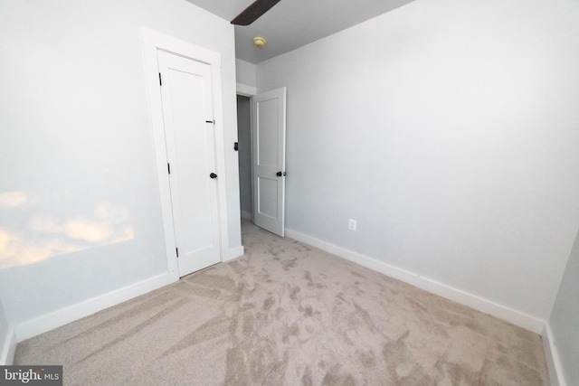 unfurnished bedroom with carpet, baseboards, and a closet