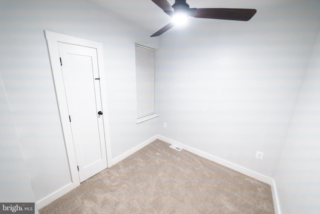 carpeted spare room with ceiling fan, visible vents, and baseboards