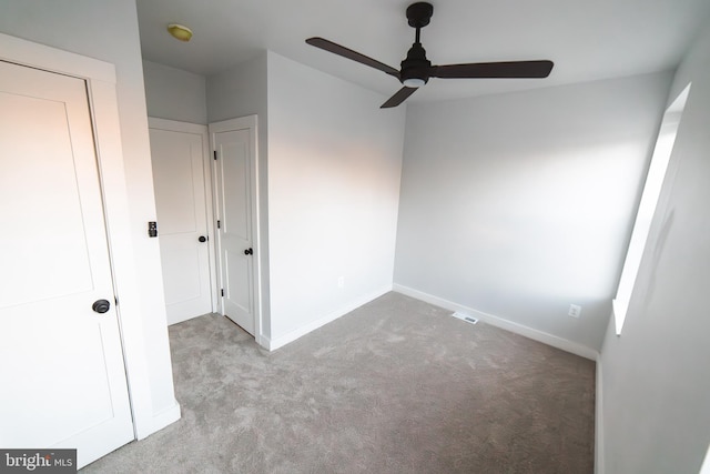 unfurnished bedroom featuring carpet, a ceiling fan, and baseboards