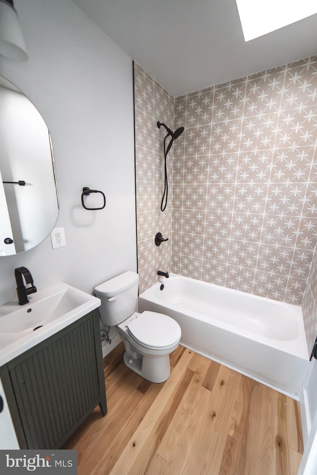 full bathroom with shower / tub combination, vanity, toilet, and wood finished floors